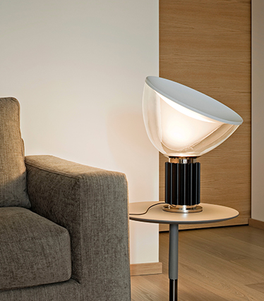 Contemporary designer lamp providing soft ambient light beside a modern sofa