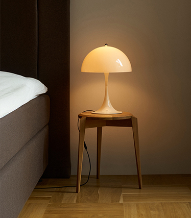 Classic mushroom-shaped bedside lamp casting gentle light in a cozy bedroom