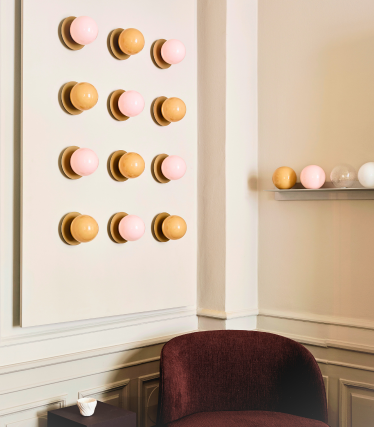 Nuura wall lights with pink and amber glass globes on brass discs