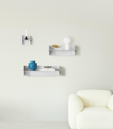 Transparent Normann Copenhagen wall shelves with decorative accessories in a minimalist living space.